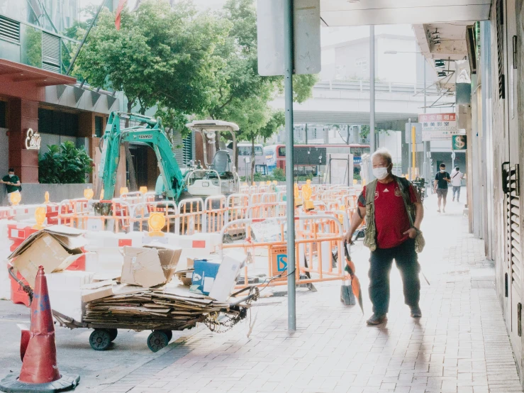 a street scene with a person walking and a lot of construction work