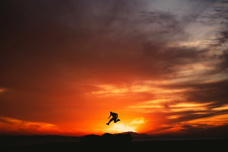 a person is jumping at the sunset on a surf board