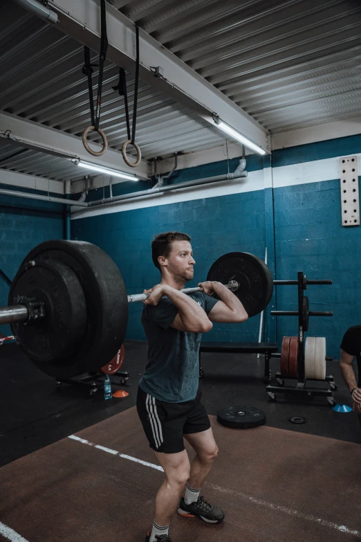 a man is lifting a heavy bar in a gym