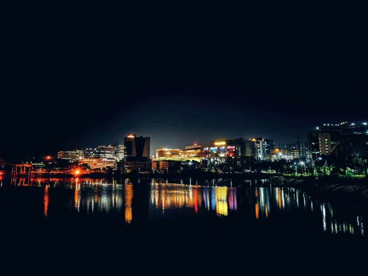 a city at night is lit up as seen from the water