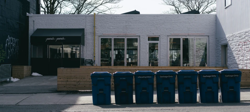 a row of trash cans in front of a building