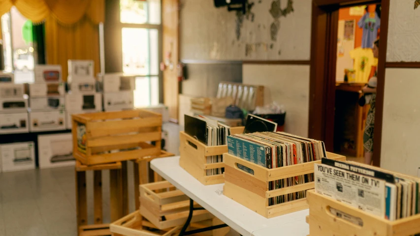 there are several wooden crates holding records on the table