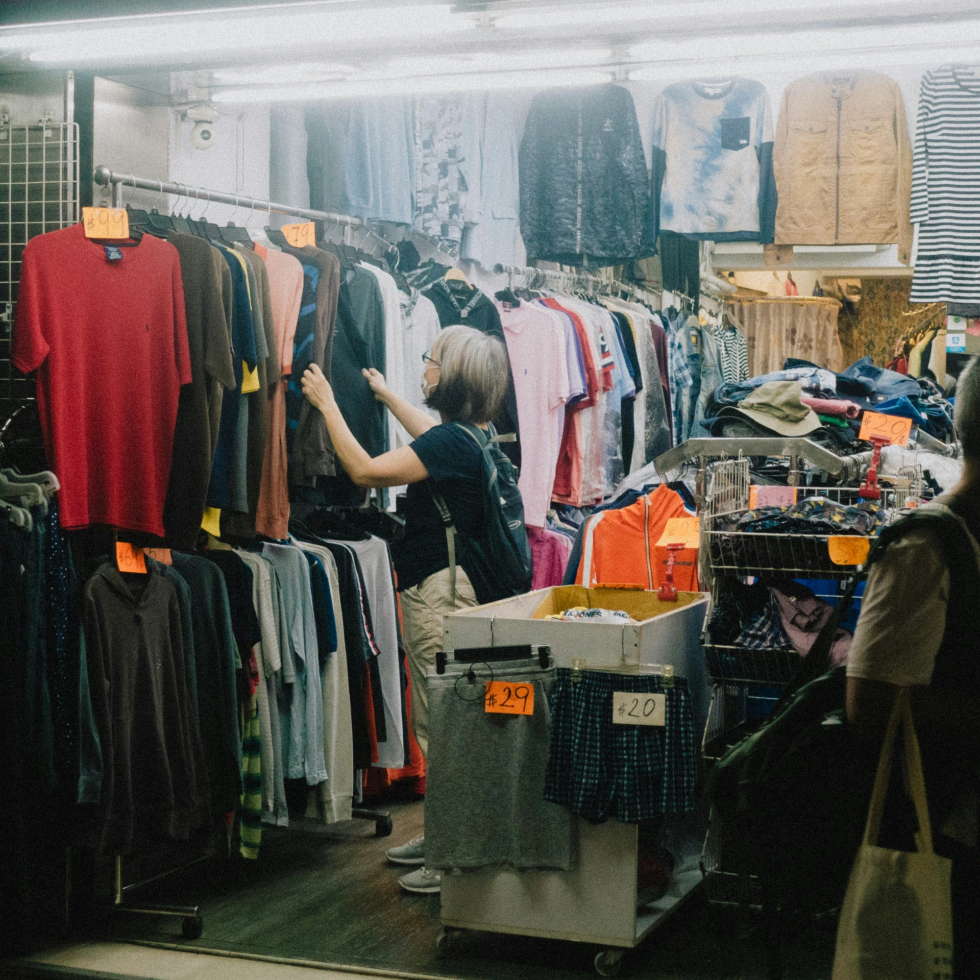 women look at shirts in a store that sells clothing