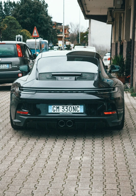 a sports car is parked on a brick street