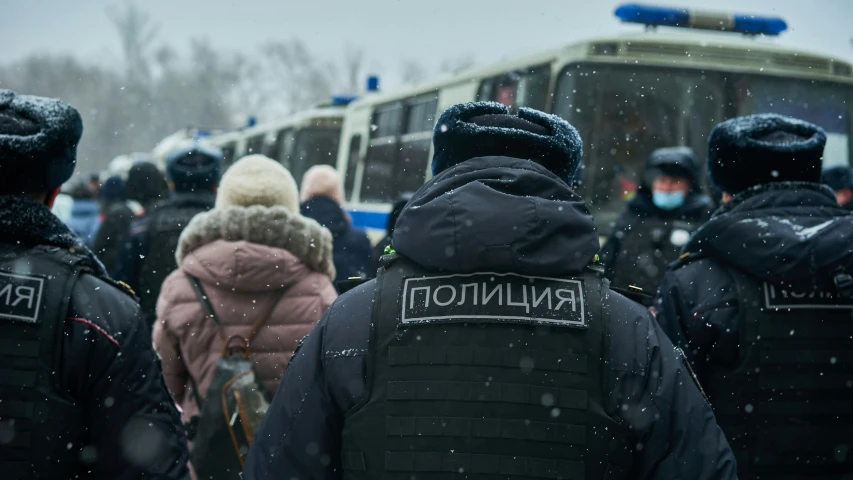 people stand in a line near a bus