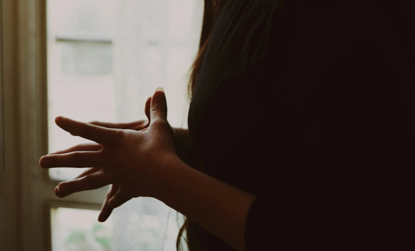 a close up s of someone's hands reaching out the window