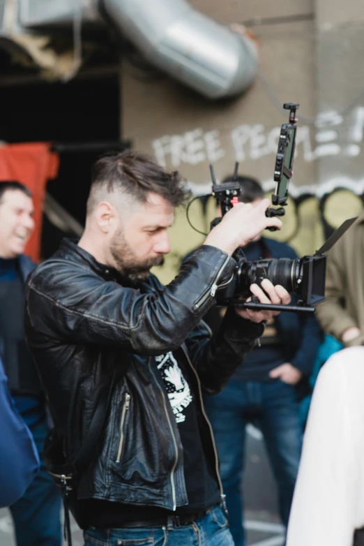 a man holding a camera and taking pictures in front of other people