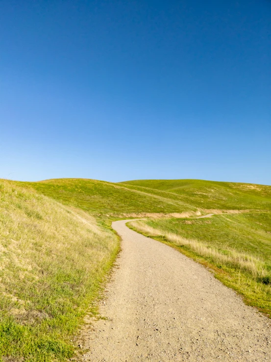 the pathway is winding down a grassy hillside