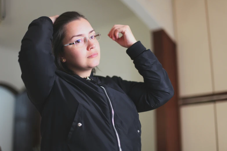 a woman in glasses adjusting her hair