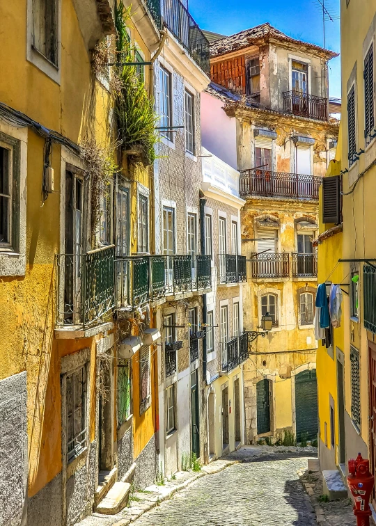 a cobblestone street in france lined with colorful buildings