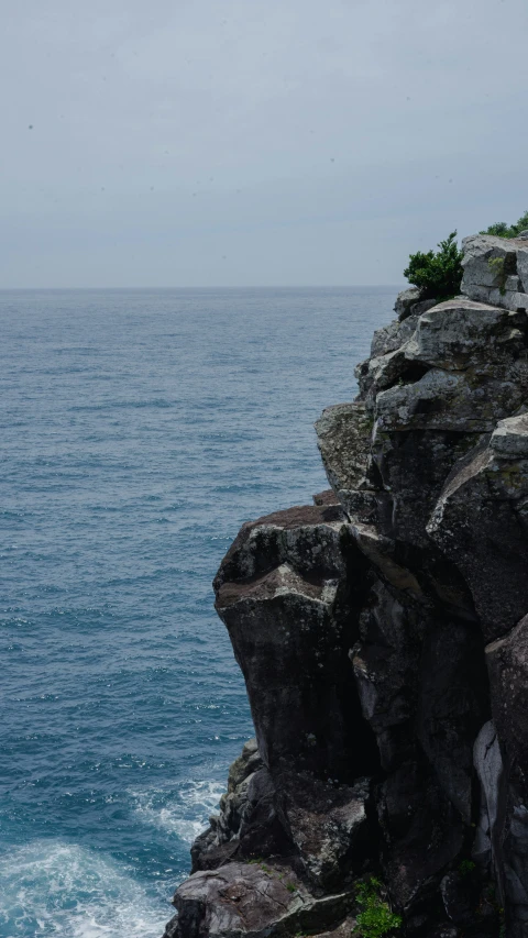 a white lighthouse sitting on the edge of a cliff