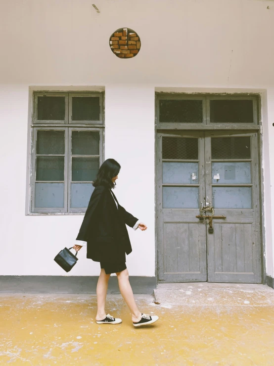 a woman walking in front of a doorway with luggage