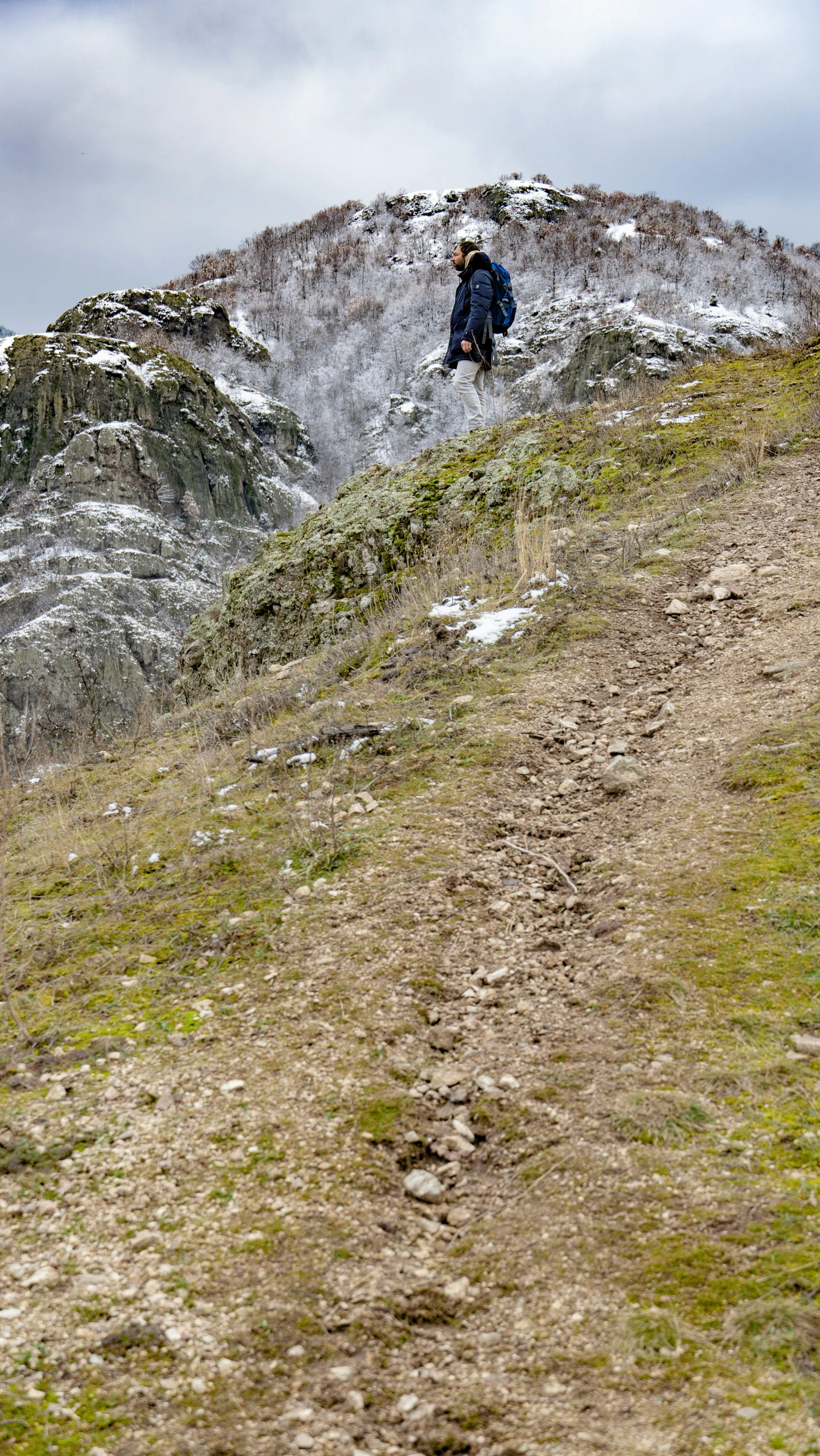 man on trail with mountains in the background