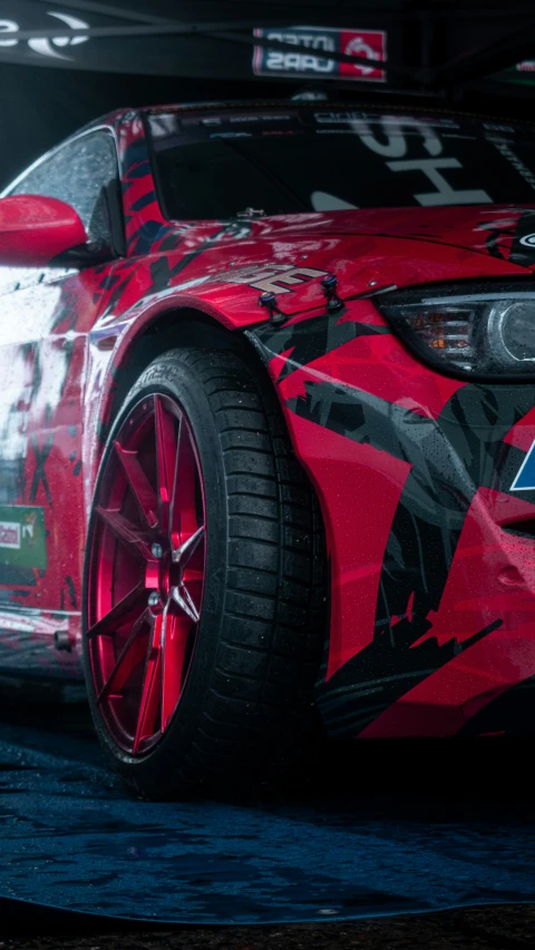 the rear wheel on a sports car with a red camouflage paint job