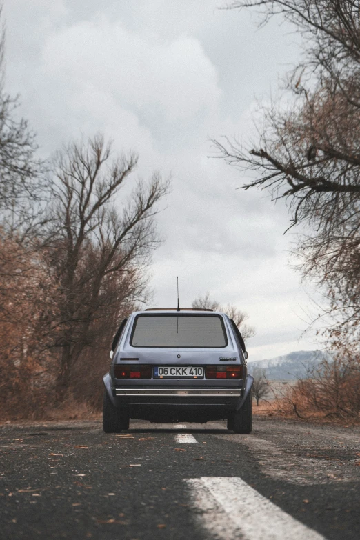 a car is driving down the road in winter