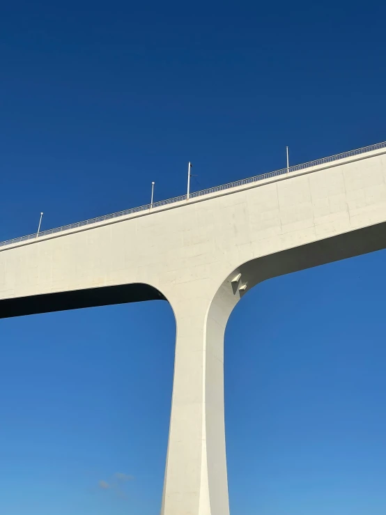 a train going over a bridge with blue skies