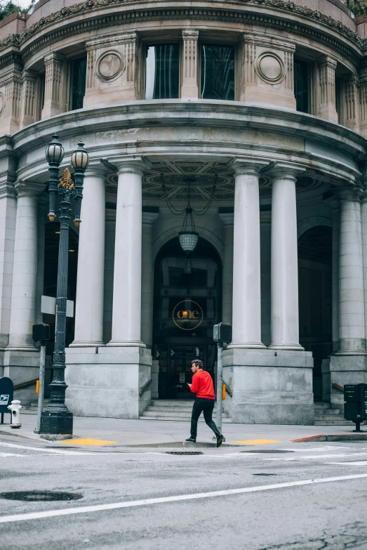 a man standing in front of a building with some columns