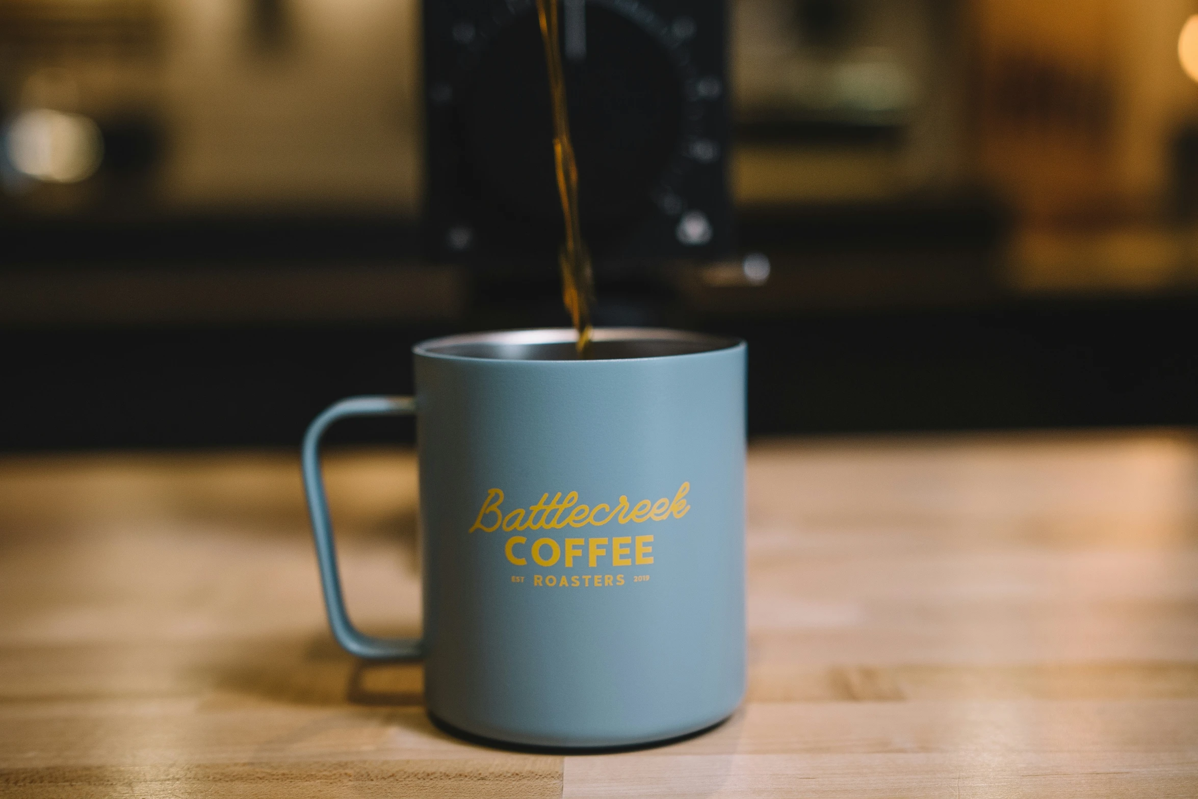 a blue coffee cup sitting on top of a wooden table