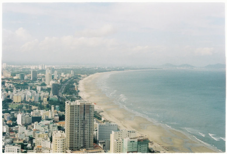 the coast is crowded with tall buildings under a cloudy sky