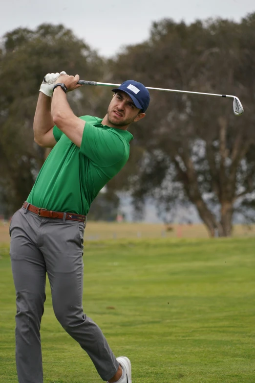 a person on a golf course swinging his golf club