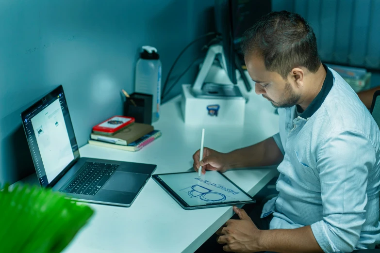 man in chair with electronic tablet writing