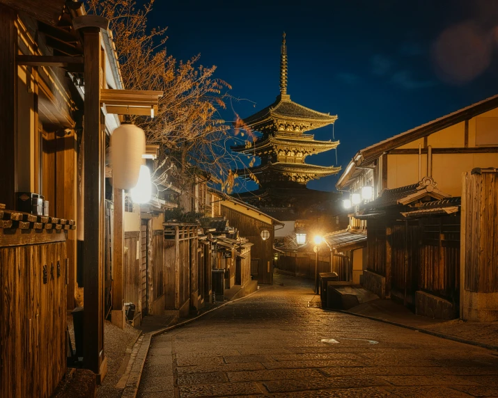 a narrow street with light poles that are shining in the night