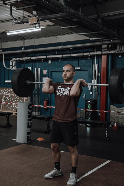 man standing in front of barbell squat machine