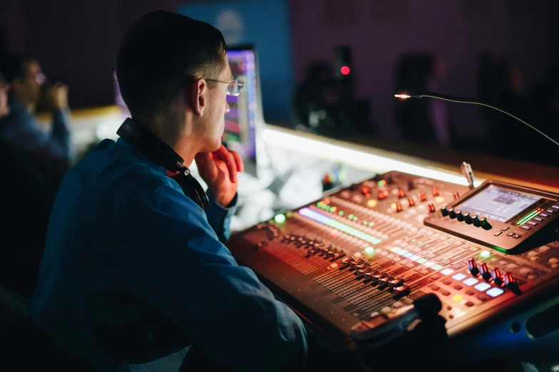 man sitting in front of a soundboard in front of a band