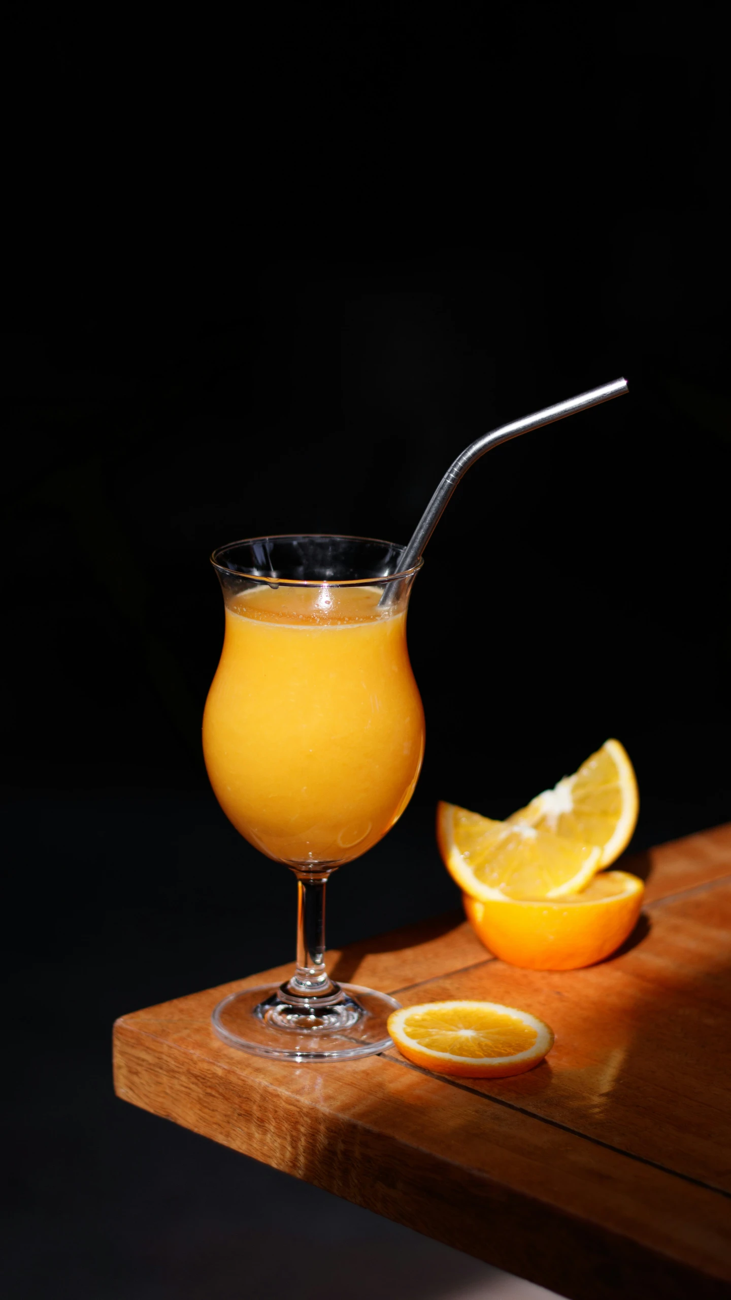 a drink next to a slice of orange on a table