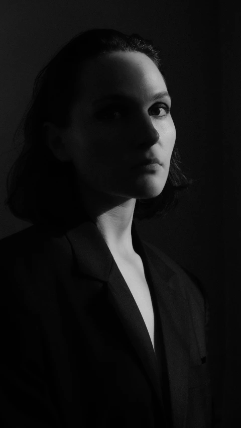 a woman looking into the distance in a dark room