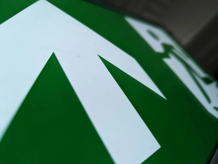 the corner of a green and white umbrella with white arrows