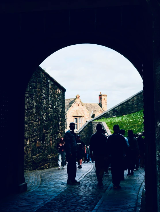 some people are walking around the building with the arched doorway