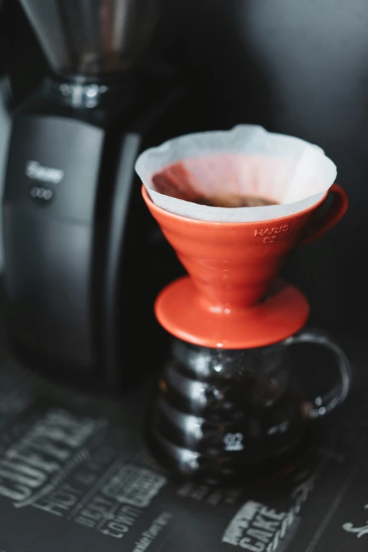 the orange pouro coffee pot on the ground near an espresso machine