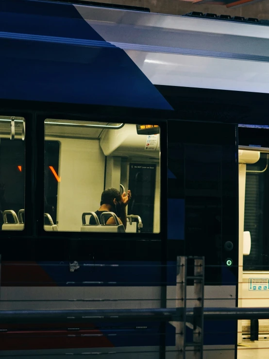 woman with glasses sits in a bus as it sits at a crosswalk