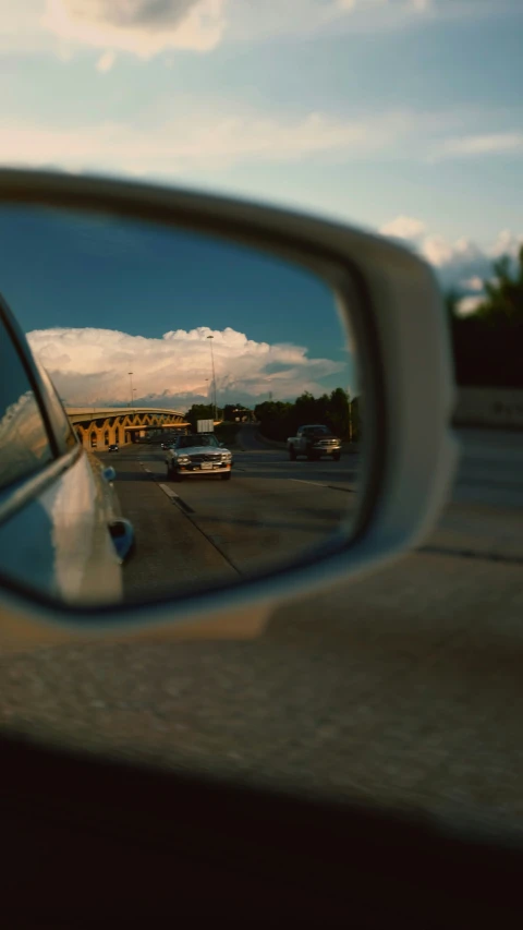 view of cars in rearview mirror from outside of car