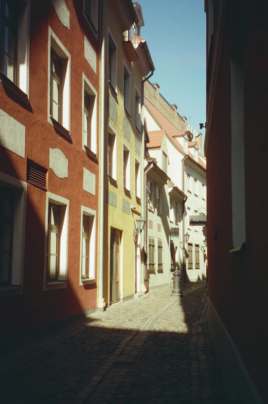 a narrow city street is shown with a red brick wall