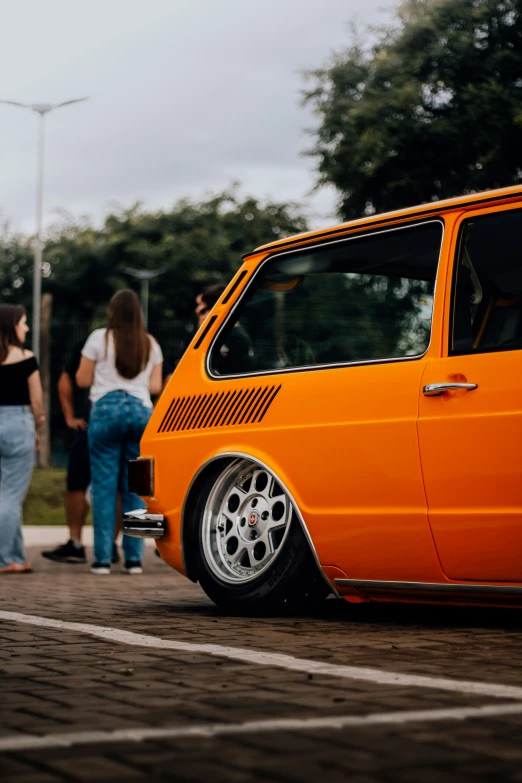 an orange wagon with a big tire and chrome trim