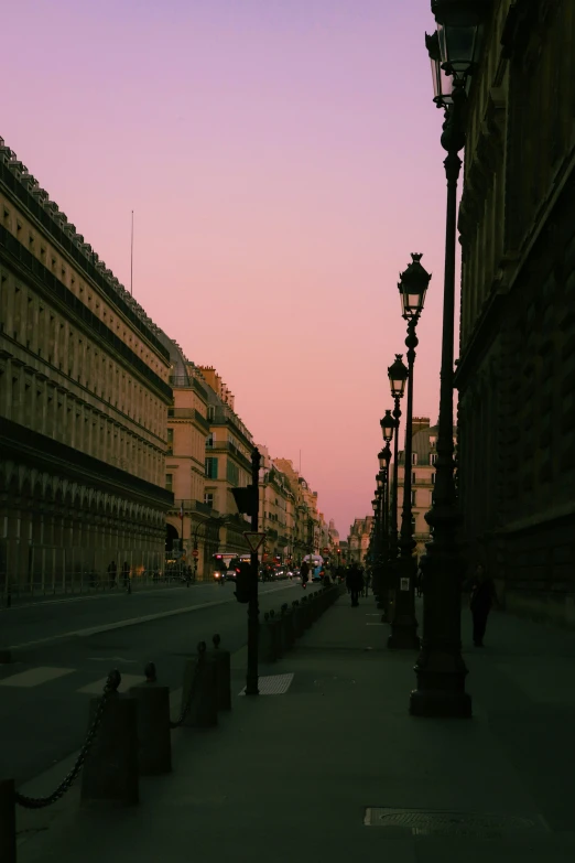 the setting sun shines over a city street and buildings