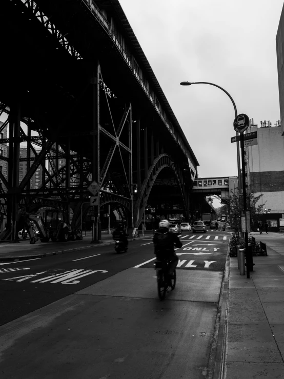 a black and white po of people riding motorcycles down a street