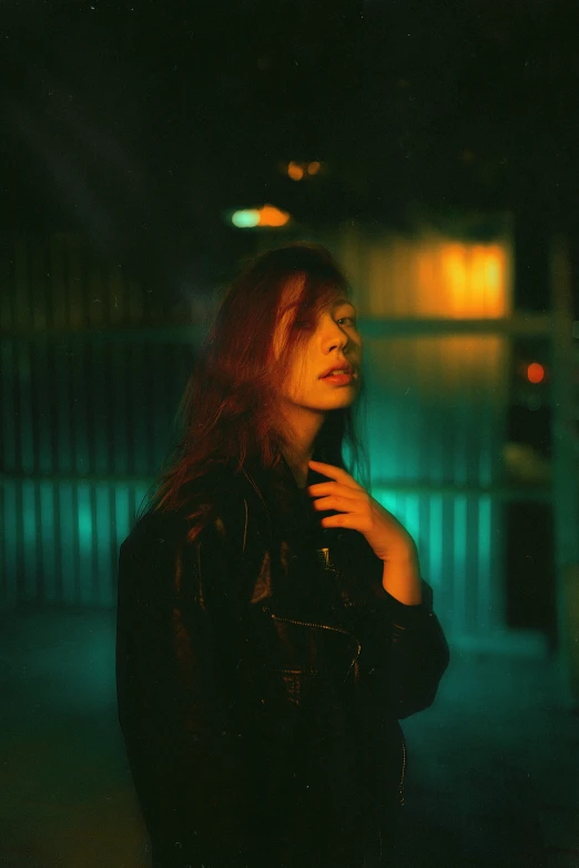 a woman with red hair standing in the dark