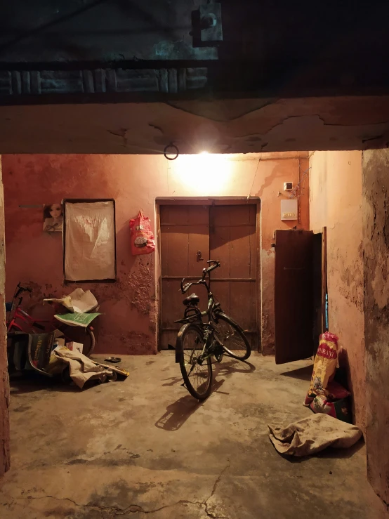 a bike is sitting inside a room near some trash