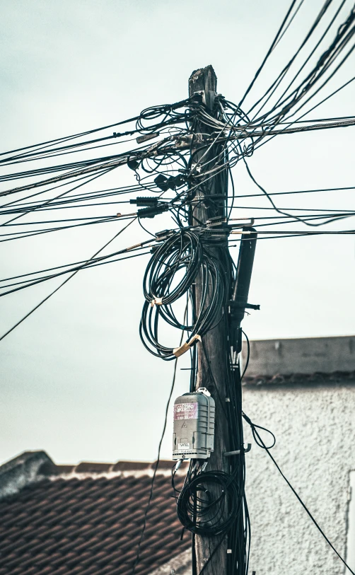 several wires and telephone poles on an overcast day