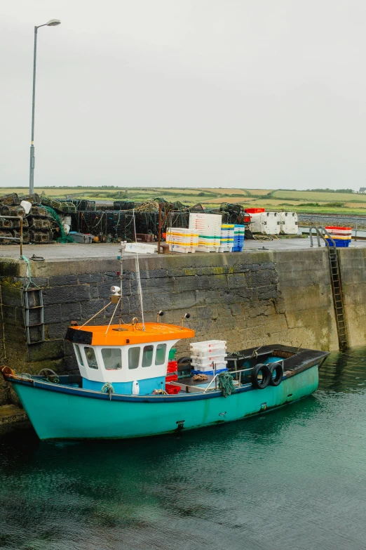 a blue boat docked at the end of a pier