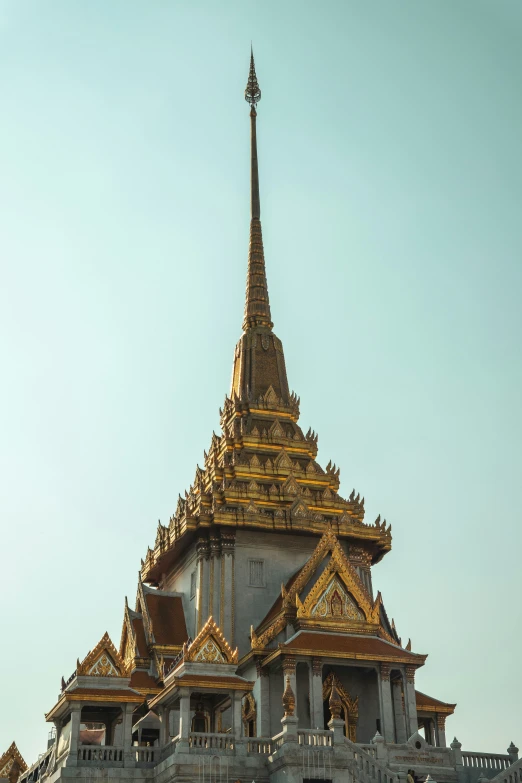 a tower with spire standing under a cloudy sky