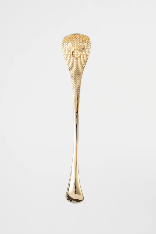 a gold spoon with a smiley face on the end