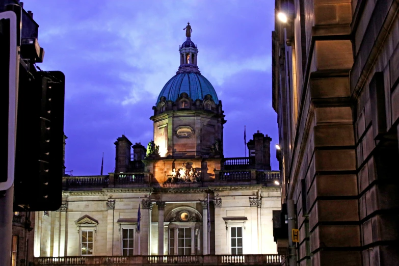 a building with a tall clock tower stands next to other buildings