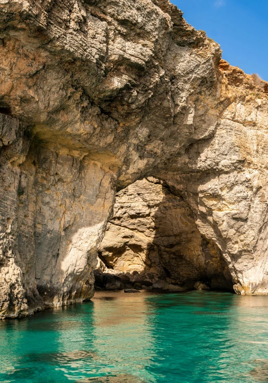 a large cave sitting on the side of a beach