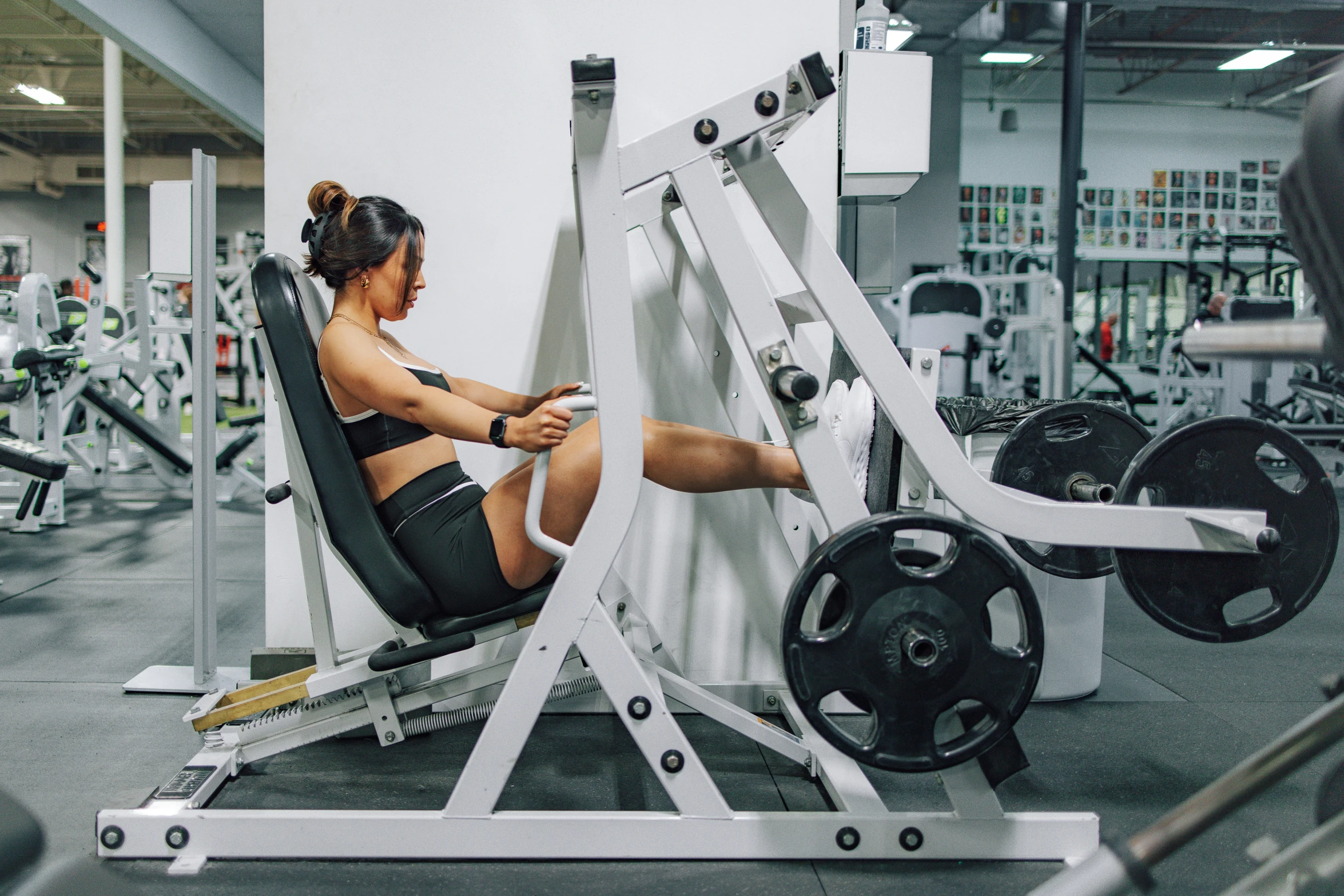 a women who is squatting with an olympic weight bench