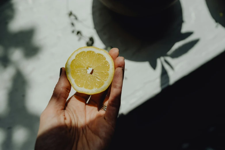 someone holding a slice of orange up to their face