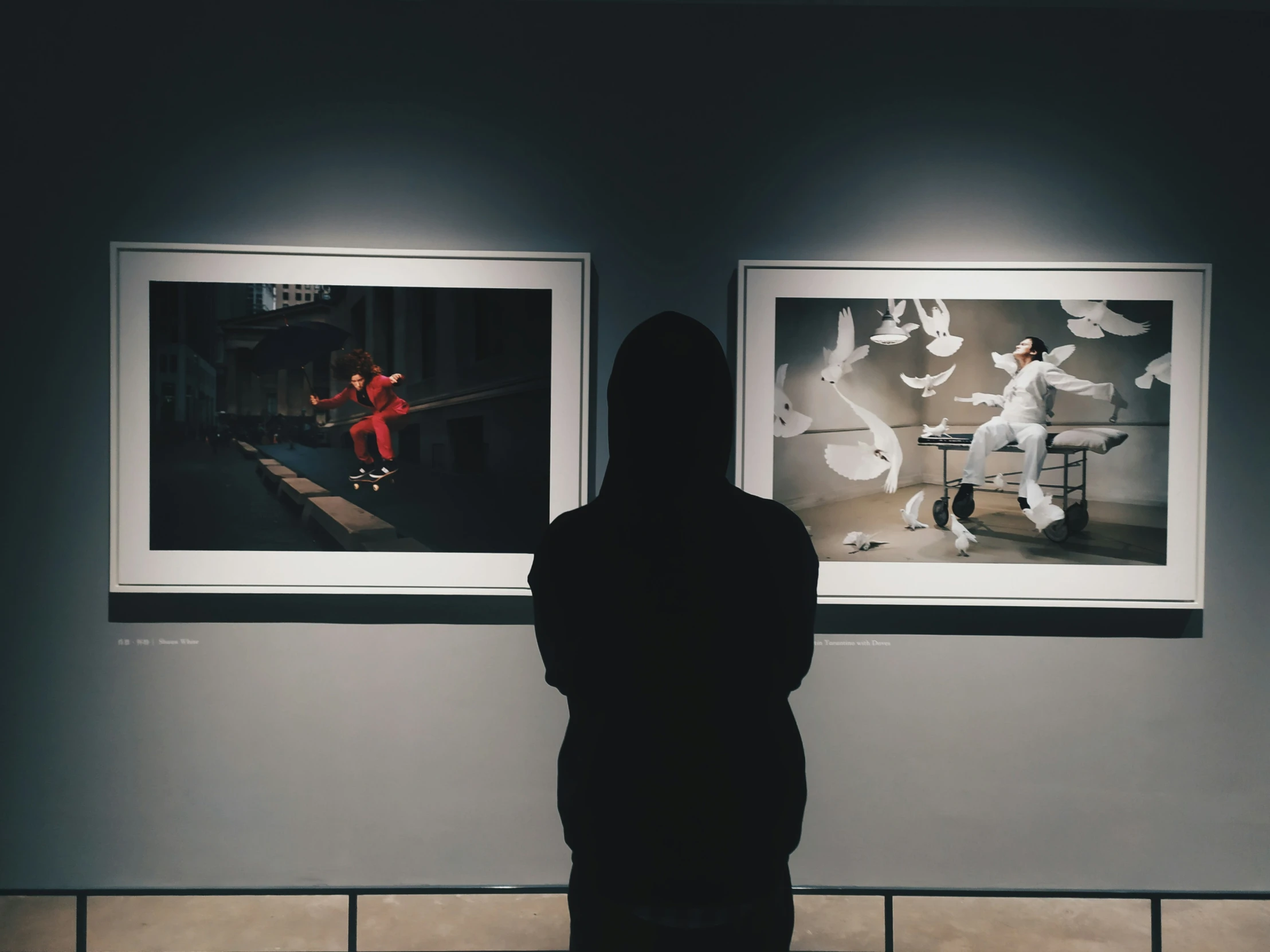 a person standing in front of two pictures hanging up on a wall